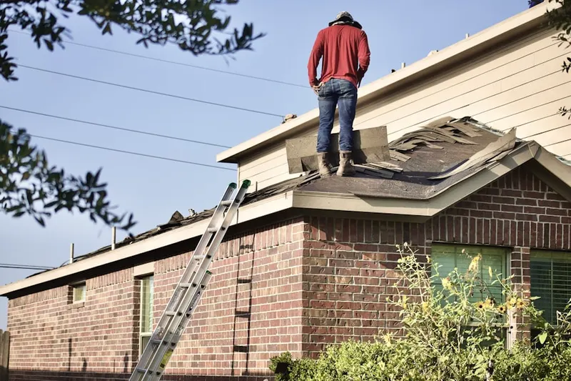 Professional roofer working on a residential roof in Firestone